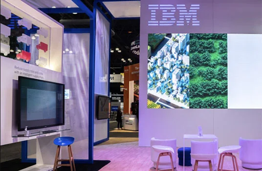 Área de demonstração IBM com telas e assentos para interação de participantes