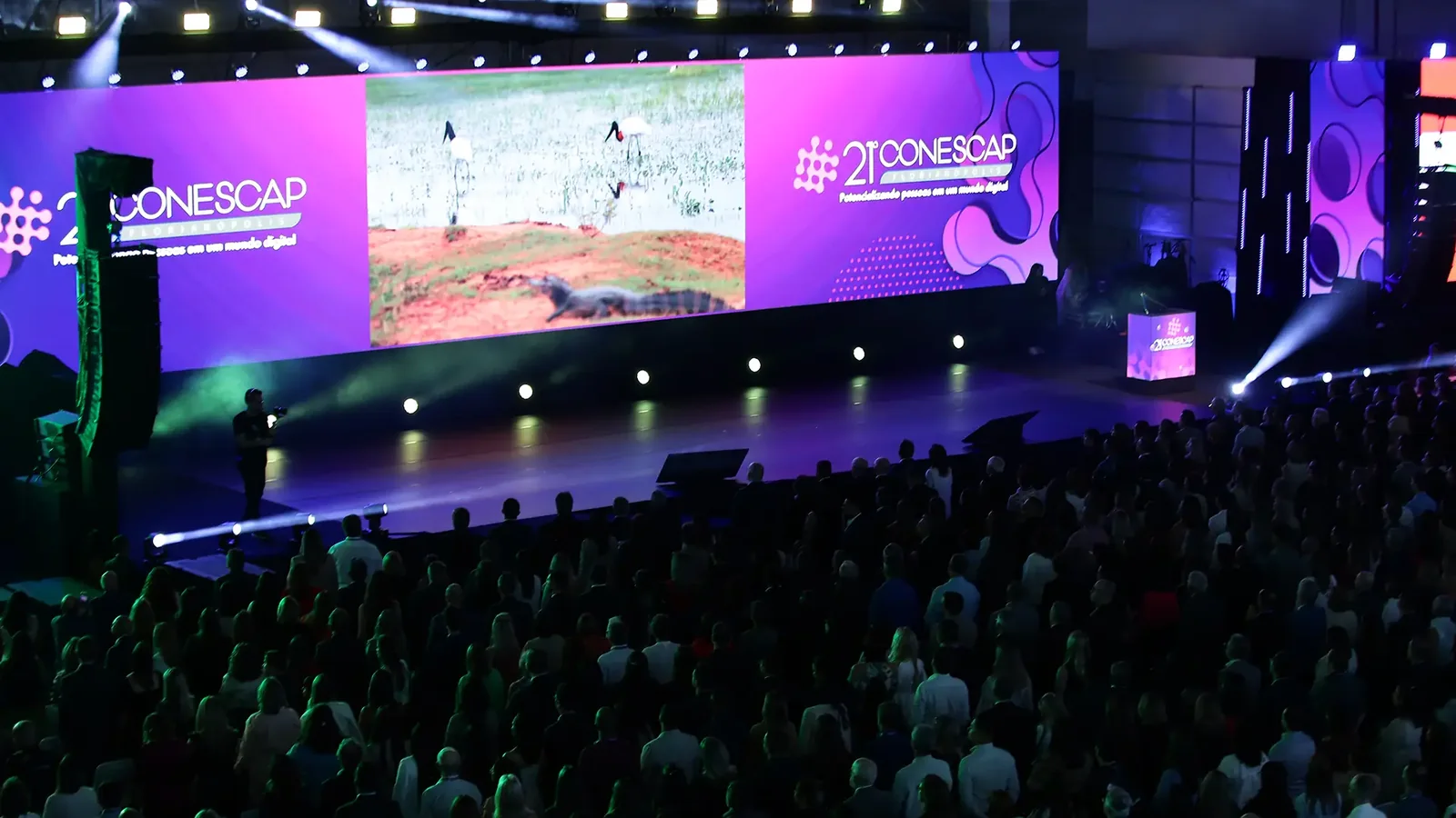 Auditório do evento CONESCAP com grande tela e público, realizado pela MCI Brasil